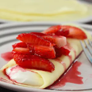Quick and easy gluten free crepes are a cinch to make! Whip a few simple ingredients in your blender, pour into a skillet, cook, flip, and repeat. They're fold-able, roll-able, filled with a tangy cheesecake filling and topped with fresh berries.