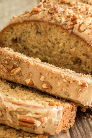 gluten free banana bread partially sliced on a cutting board