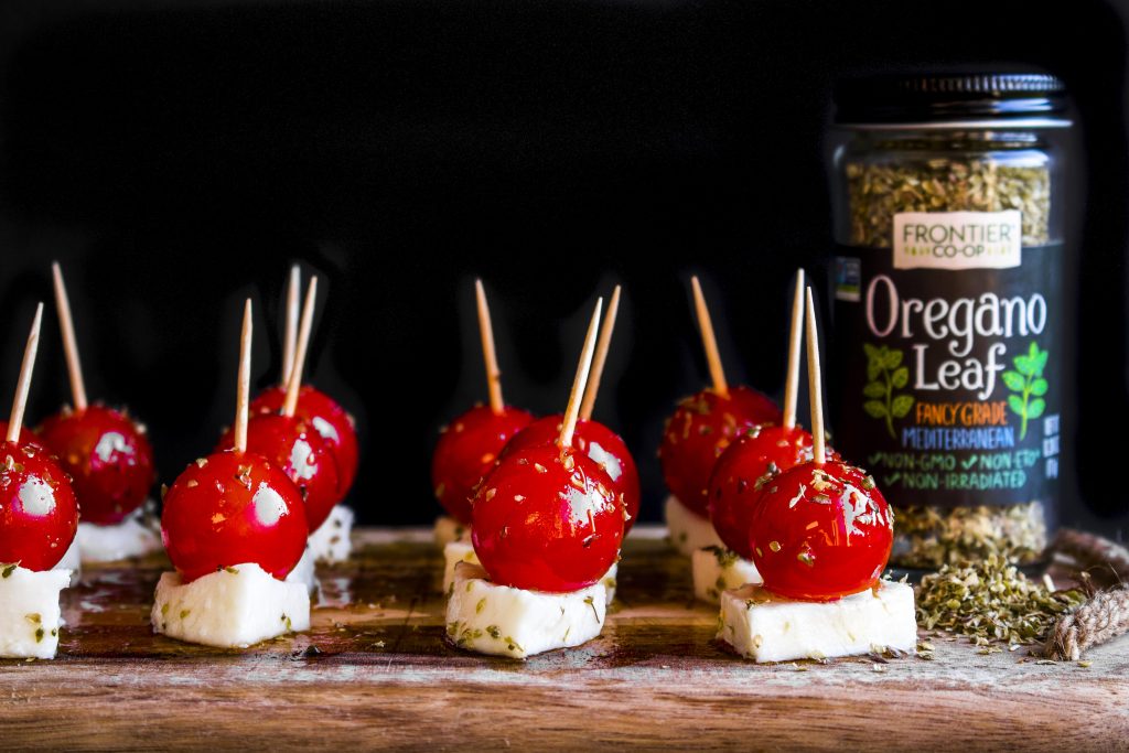 There's a new Caprese on the block! Olive oil infused with garlic and oregano, and drizzled over fresh mozzarella and tomatoes for the ultimate crowd pleaser!