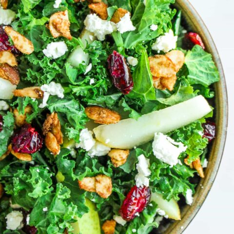 Cranberry Kale salad is a deliciously festive dish with tart cranberries, crisp kale, and sweet pears. It is topped with fresh gorgonzola and cardamom spiced almonds then drizzled with a homemade cranberry vinaigrette. It is the perfect marriage of flavors and a great addition to any party or get together. Simple enough to make for lunch but also beautiful for a more formal meal.