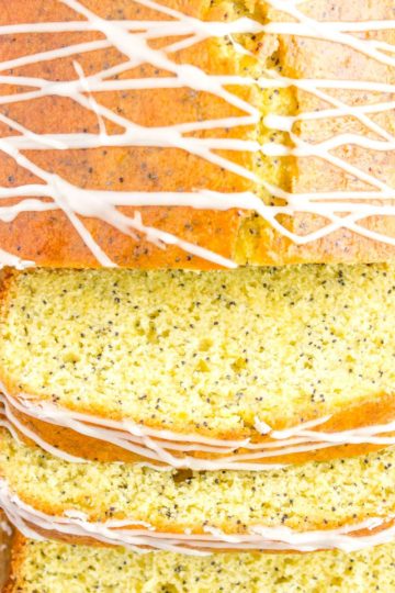 a loaf of gluten free orange poppy seed bread partially sliced and drizzled with glaze