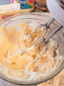 creamy honey butter in a glass bowl right after being mixed with a hand mixer