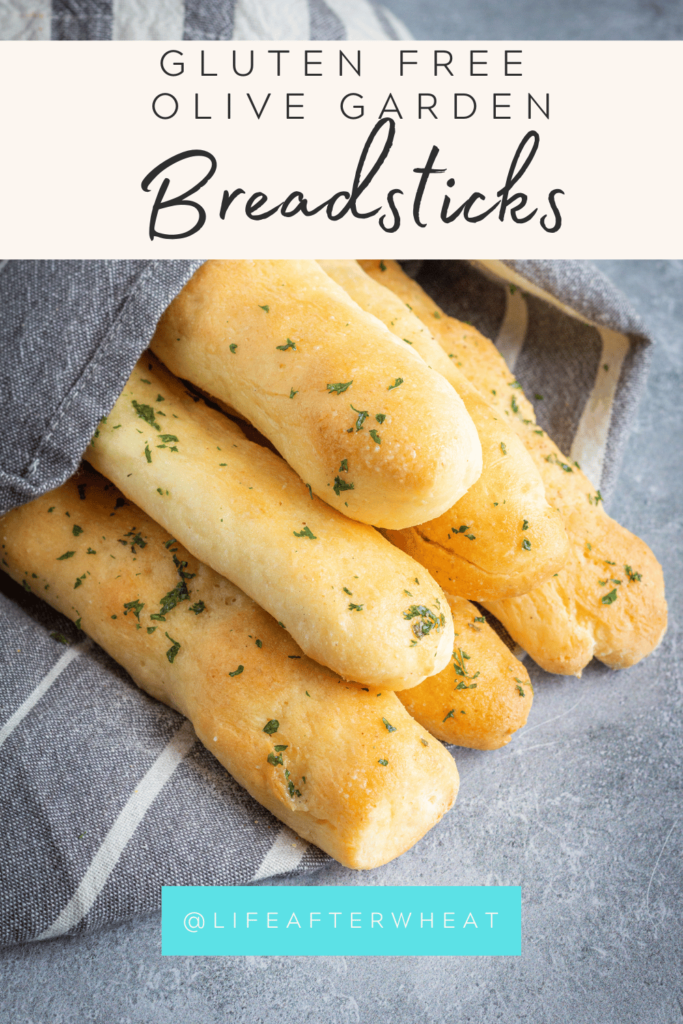 A pinterest friendly image of a stack of breadsticks sprinkled in parsley.