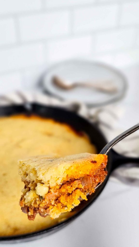 layers of meat and cornbread in a bite of tamale pie