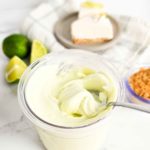 a spoon in a container of creamy ice cream
