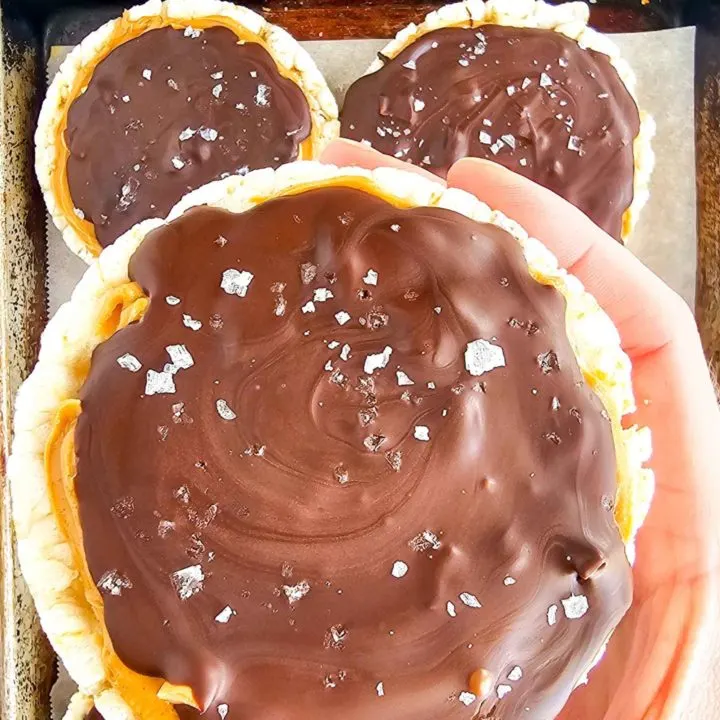 a hand holding a chocolate covered dessert