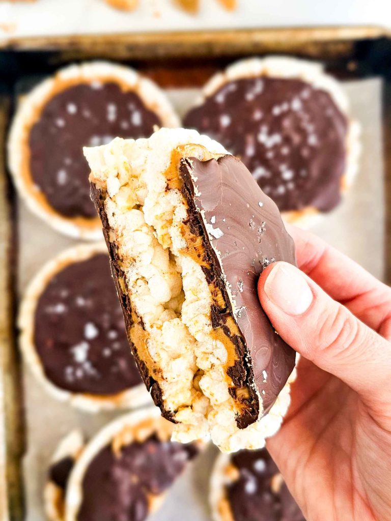 a hand holding a chocolate covered rice cake